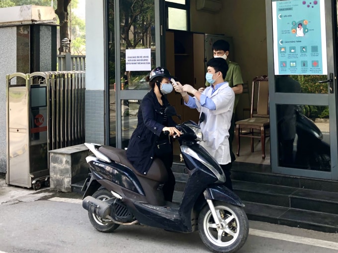 Cán bộ y tế kiểm tra thân nhiệt tất cả mọi người vào trụ sở cơ quan Bộ