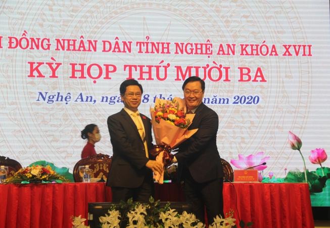 Ông Nguyễn Xuân Sơn - Phó Bí thư Thường trực Tỉnh ủy, Chủ tịch HĐND tỉnh (bên trái) tặng hoa cho tân Chủ tịch UBND tỉnh Nguyễn Đức Trung