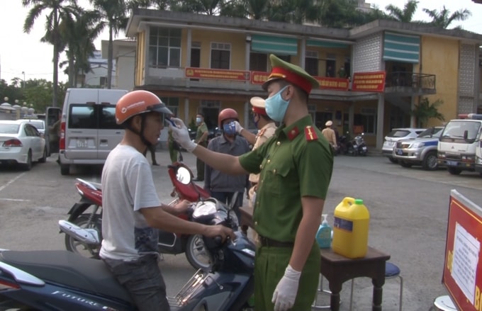 Công an TP. Huế sát khuẩn, đo thân nhiệt cho người dân khi đến làm việc tại đơn vị.