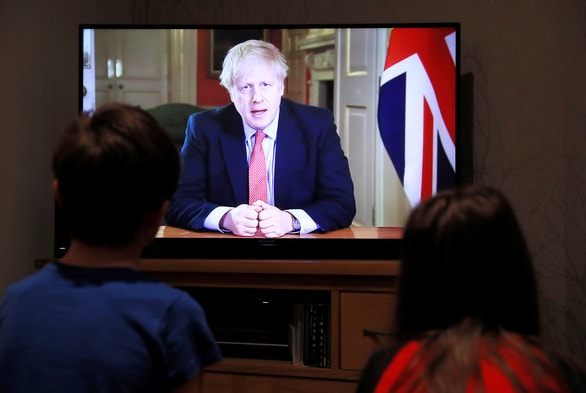 Người dân theo dõi Thủ tướng Anh Boris Johnson phát biểu qua truyền hình ngày 23/3. Ảnh: Reteurs.