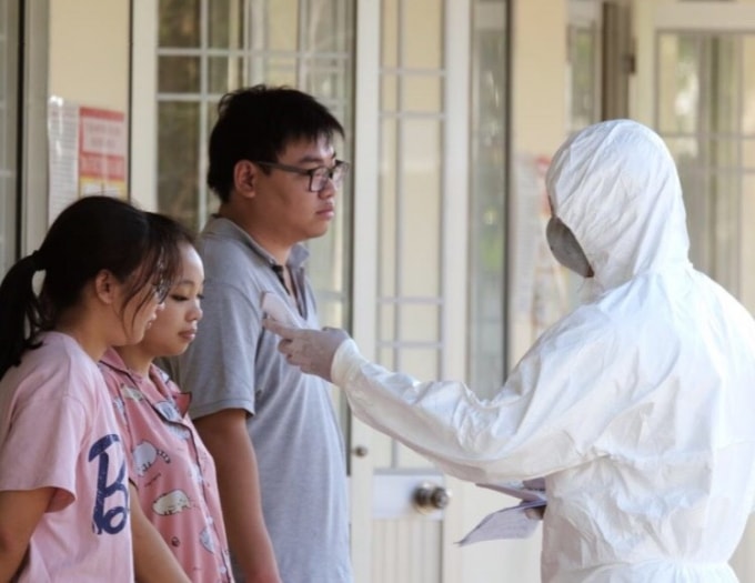 Cán bộ y tế phải thường xuyên thực hiện đo thân nhiệt và kiểm tra sức khỏe cho người dân trong khu cách ly.