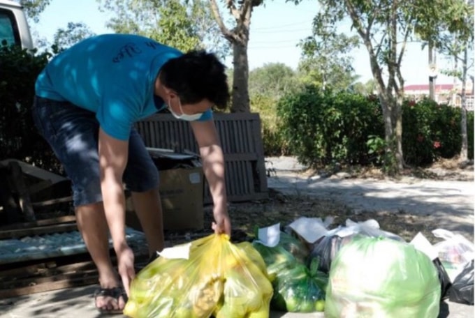 Sau khi đi mua từ nhiều chợ, một cán bộ y tế đang soạn lại các túi đồ người dân nhờ mua hộ để giao vào trong.
