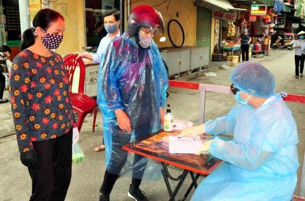 Chợ cột 3 thực hiện khai báo y tế, kiểm tra thân nhiệt cho người dân khi vào chợ. ẢNh: Minh Hà.