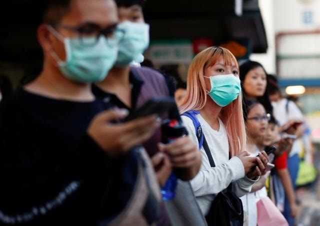 Người dân đeo khẩu trang tại một bến xe bus ở Singapore. Ảnh: Reuters