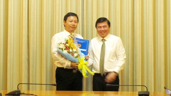 Chủ tịch UBND TPHCM Nguyễn Thành Phong (phải) trao quyết định và tặng hoa chúc mừng ông Dương Anh Đức tân Phó chủ tịch UBND TP HCM