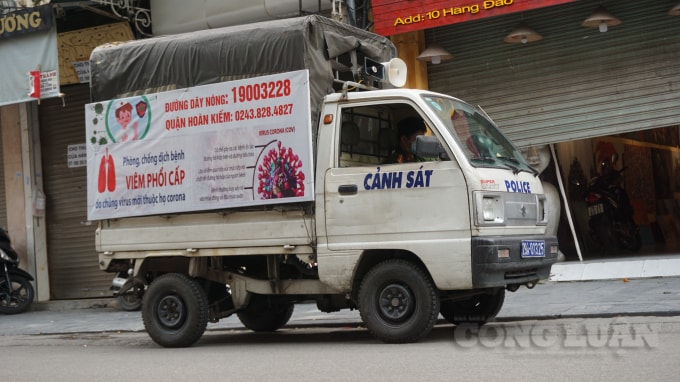 Trên các tuyến phố cảnh sát đi gõ cửa từng hộ kinh doanh để vận động, tuyên truyền công tác phòng, chống dịch bệnh. Ảnh H.Long.