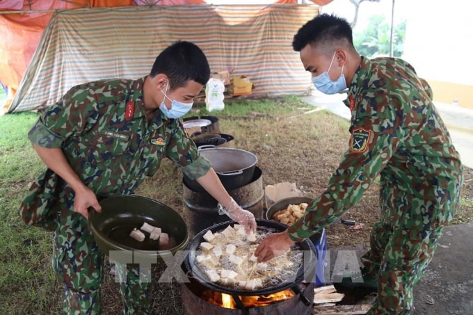 Các chiến sĩ Trung đoàn 58, Sư đoàn 308 (Quân đoàn 1) chuẩn bị lương thực, thực phẩm chăm lo bữa ăn cho người thực hiện cách ly tập trung tại đơn vị. Ảnh: TTXVN
