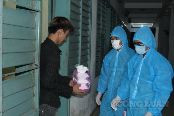 Cấp phát cơm cho bà con. Ảnh:PV