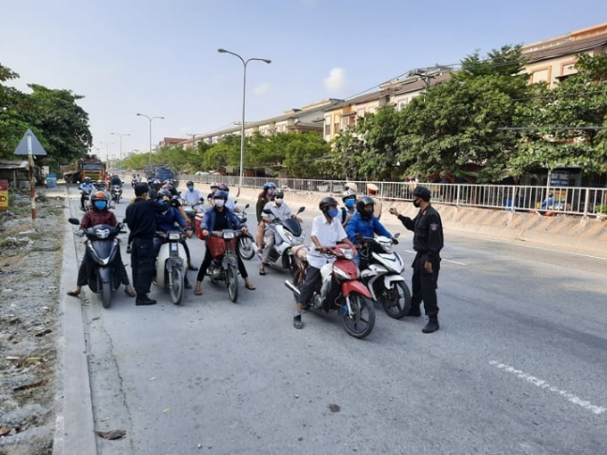 Lực lượng công an Đồng Nai đo thân nhiệt người dân tại tuyến đường Quốc lộ 1K -ảnh: N/T
