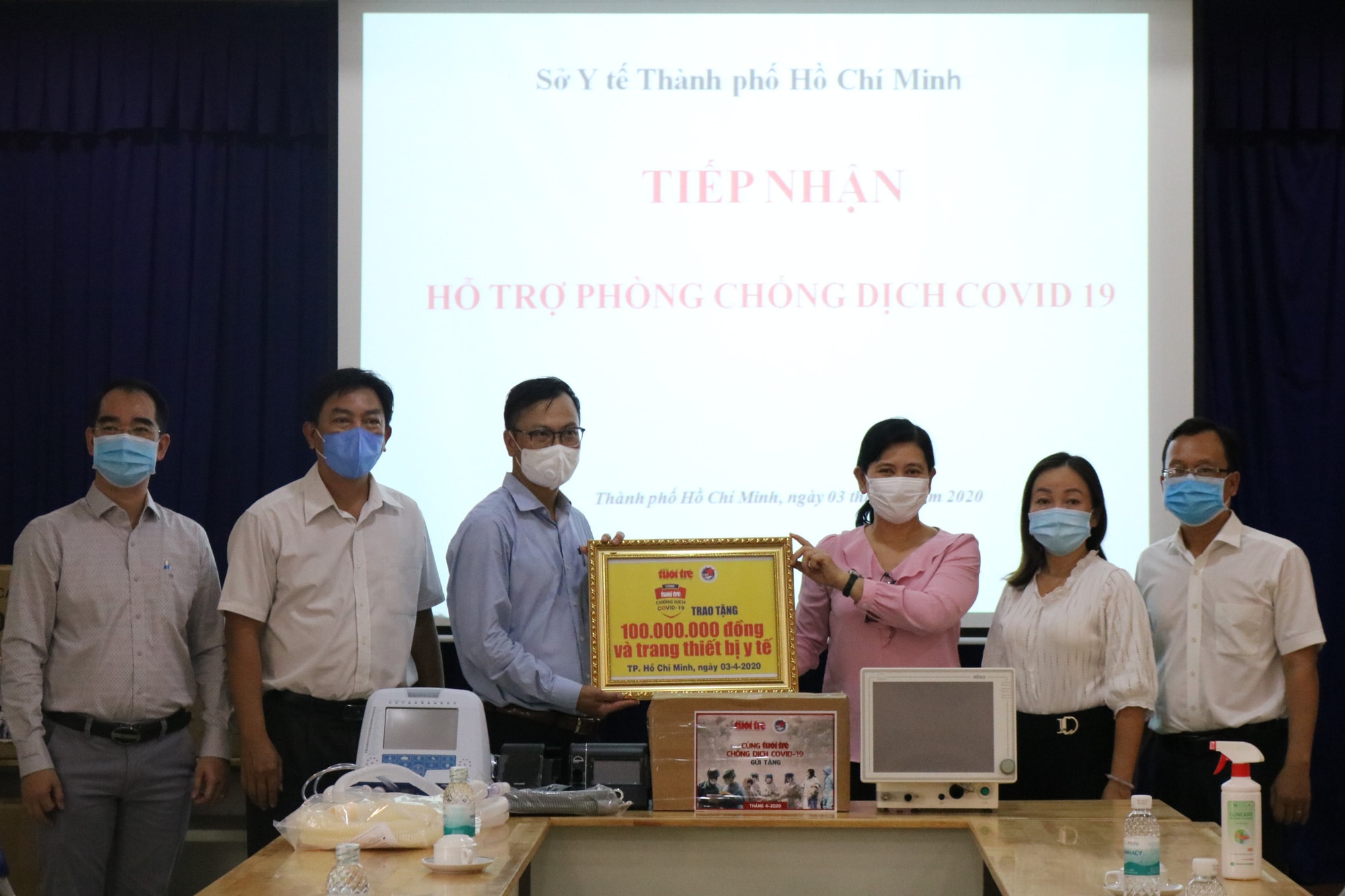 Đại diện báo Tuổi Trẻ cùng Hội Doanh nhân trẻ, các doanh nghiệp trao tặng tiền mặt và trang thiết bị y tế cho đại diện Sở Y tế TP.HCM. Ảnh: PV