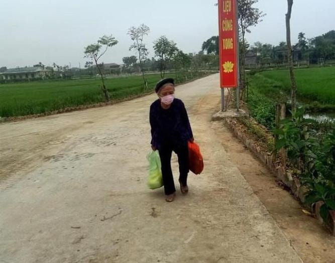 Cụ Nguyễn Thị Ba mang theo 5 kg và một túi rau tự hái rồi đi bộ từ nhà đến ủng họ khu cách ly tập trung. Ảnh Sỹ Đức