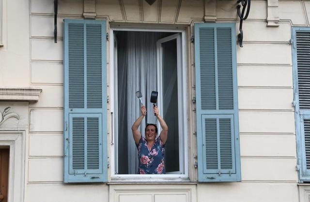 Người dân Paris gõ nồi bên cửa sổ nhằm cảm ơn những y bác sĩ đang căng mình trong mùa dịch. Ảnh:Reuters