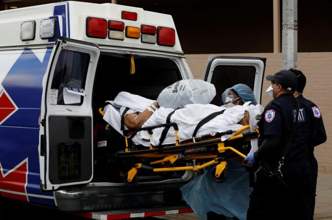 Một bệnh nhân nhiễm virus Corona được vận chuyển lên xe cứu thương tại New York, Mỹ. Ảnh: Reuters
