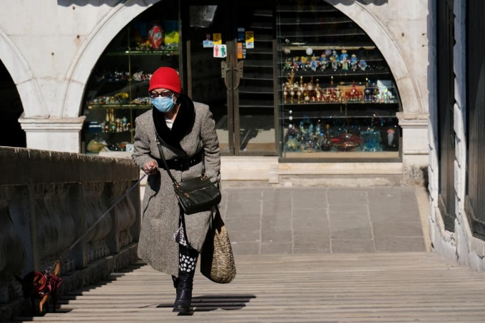 Một phụ nữ dắt chó đi dạo ở Venice, Italy. Ảnh: Reuters
