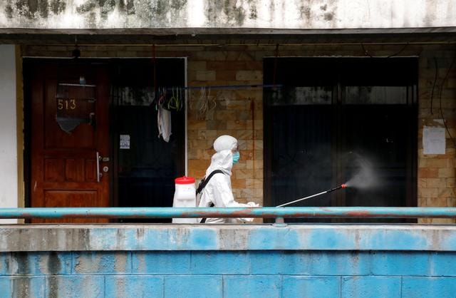 Một nhân viên phun thốc khử trùng tại một chung cư ở Jakarta, Indonesia. Ảnh: Reuters
