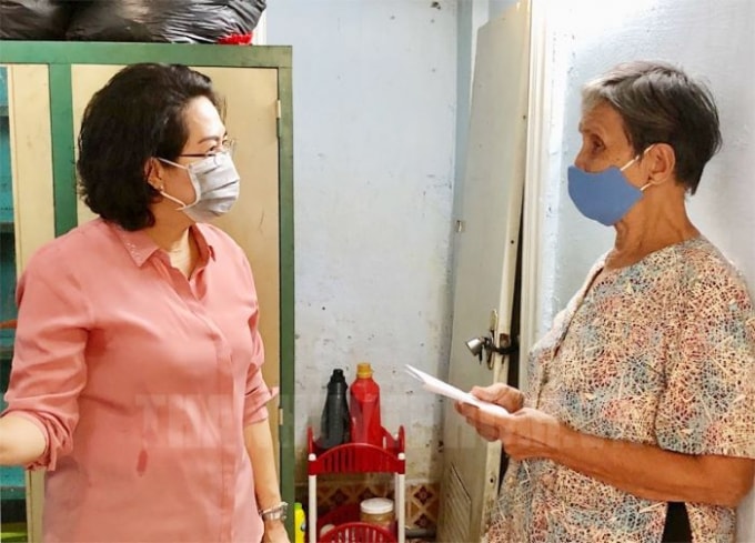 Bà Tô Thị Bích Châu, Chủ tịch Ủy ban MTTQ Việt Nam TP.HCM trao tiền hỗ trợ cho người dân bán vé số lưu động tại quận Phú Nhuận sáng 7/4/2020