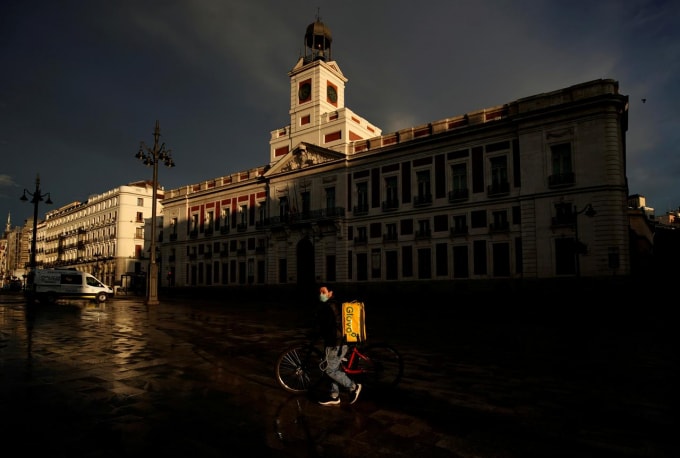 Một nhân viên giao hàng giữa tâm dịch tại Madrid, Tây Ban Nha. Ảnh:Reuters