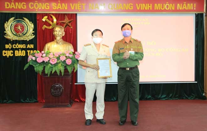 Thiếu tướng Bùi Minh Giám trao Quyết định cho Thượng tá Nguyễn Anh Tuấn, Phó Cục trưởng Cục Đào tạo. Ảnh: CAND