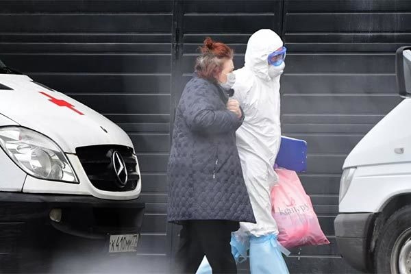Một bác sĩ đang đưa bệnh nhân đi xét nghiệm Covid-19 ở Moscow, Nga. Ảnh: Sputnik