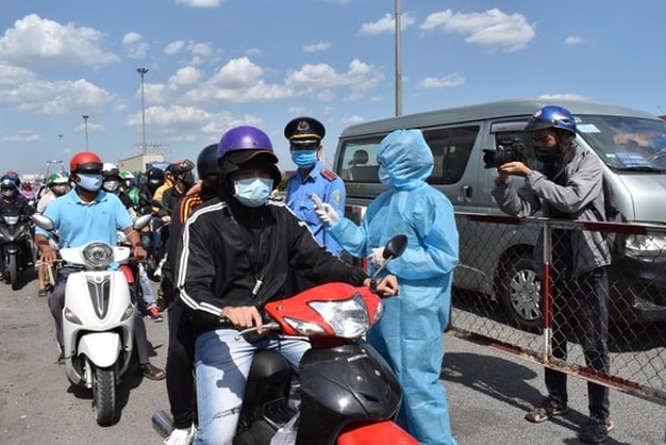 Lực lượng chức năng của TP Hồ Chí Minh kiểm tra thân nhiệt người vào Thành phố. Ảnh: SGGP