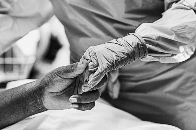 Một bác sĩ cầm tay bệnh nhân để an ủi họ. Gia đình người bệnh không được phép vào các phòng ICU. Ảnh: KC