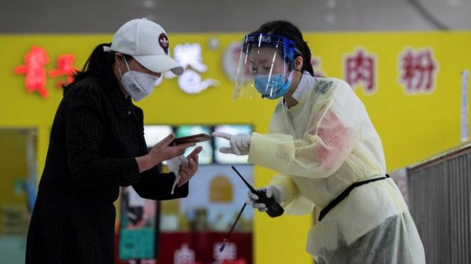 Một hành khách nói chuyện với một nhân viên trạm xe buýt ở Vũ Hán - Ảnh: AFP/ Getty Images