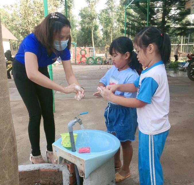 Các em học sinh được các bạn đoàn viên cơ sở hướng dẫn rửa tay sát khuẩn