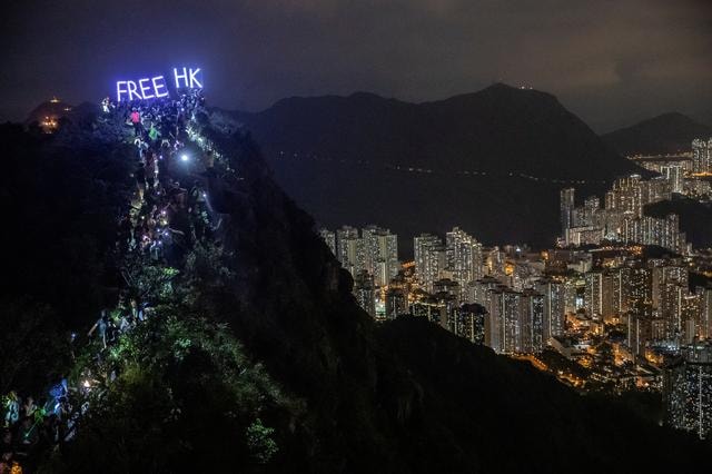 Hàng trăm người leo lên đỉnh núi Lion Rock cùng với dòng chữ