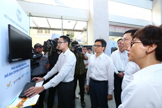 Phó Thủ tướng Vũ Đức Đam cùng các đại biểu xem thao tác trực tiếp trên nền tảng Vpostcode. Ảnh: VGP