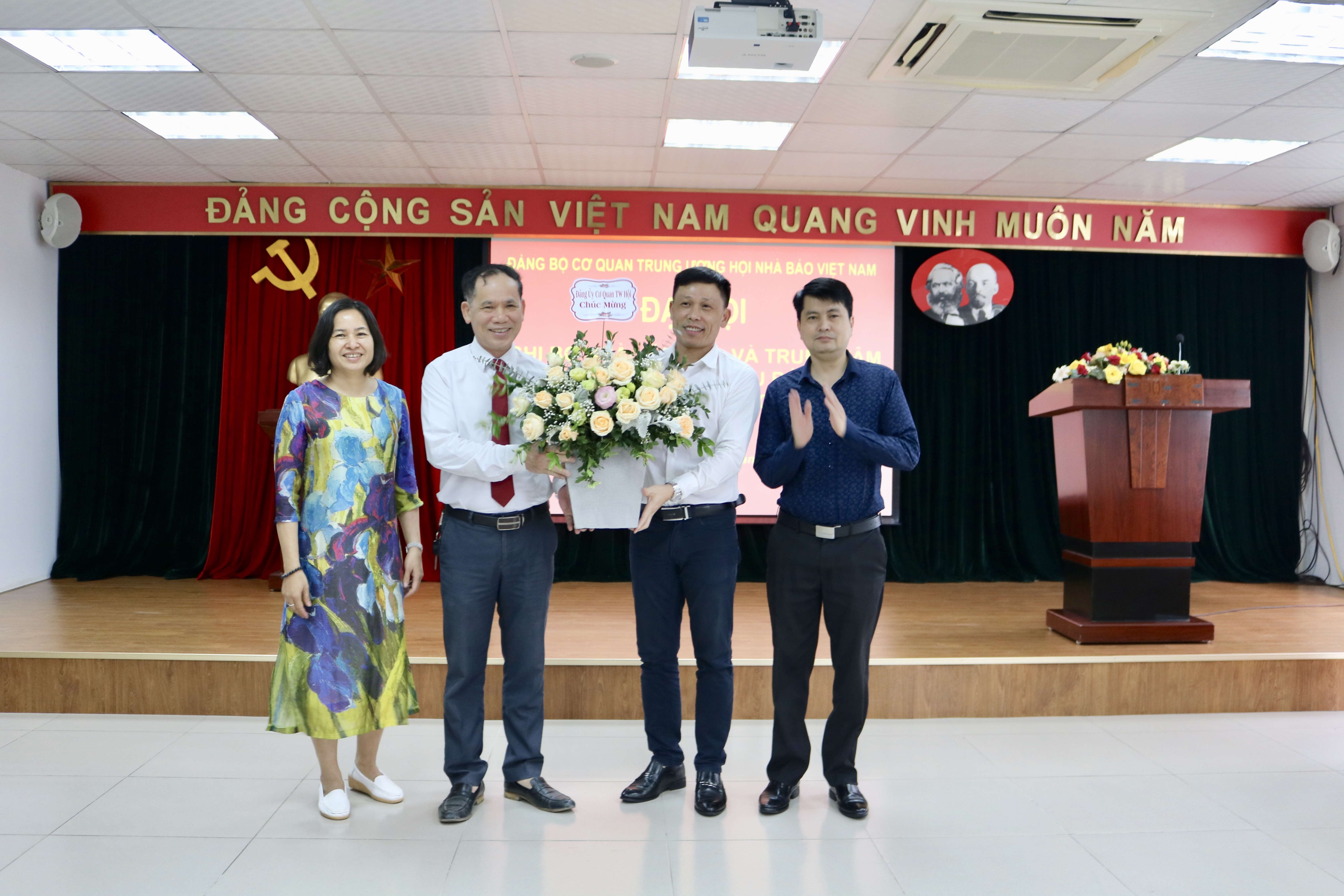 Đồng chí Nguyễn Thế Dũng - Bí thư Chi bộ Nhà Văn hóa & Trung tâm Bồi dưỡng nghiệp vụ báo chí nhiệm kỳ 2017-2020 đón nhận hoa chúc mừng