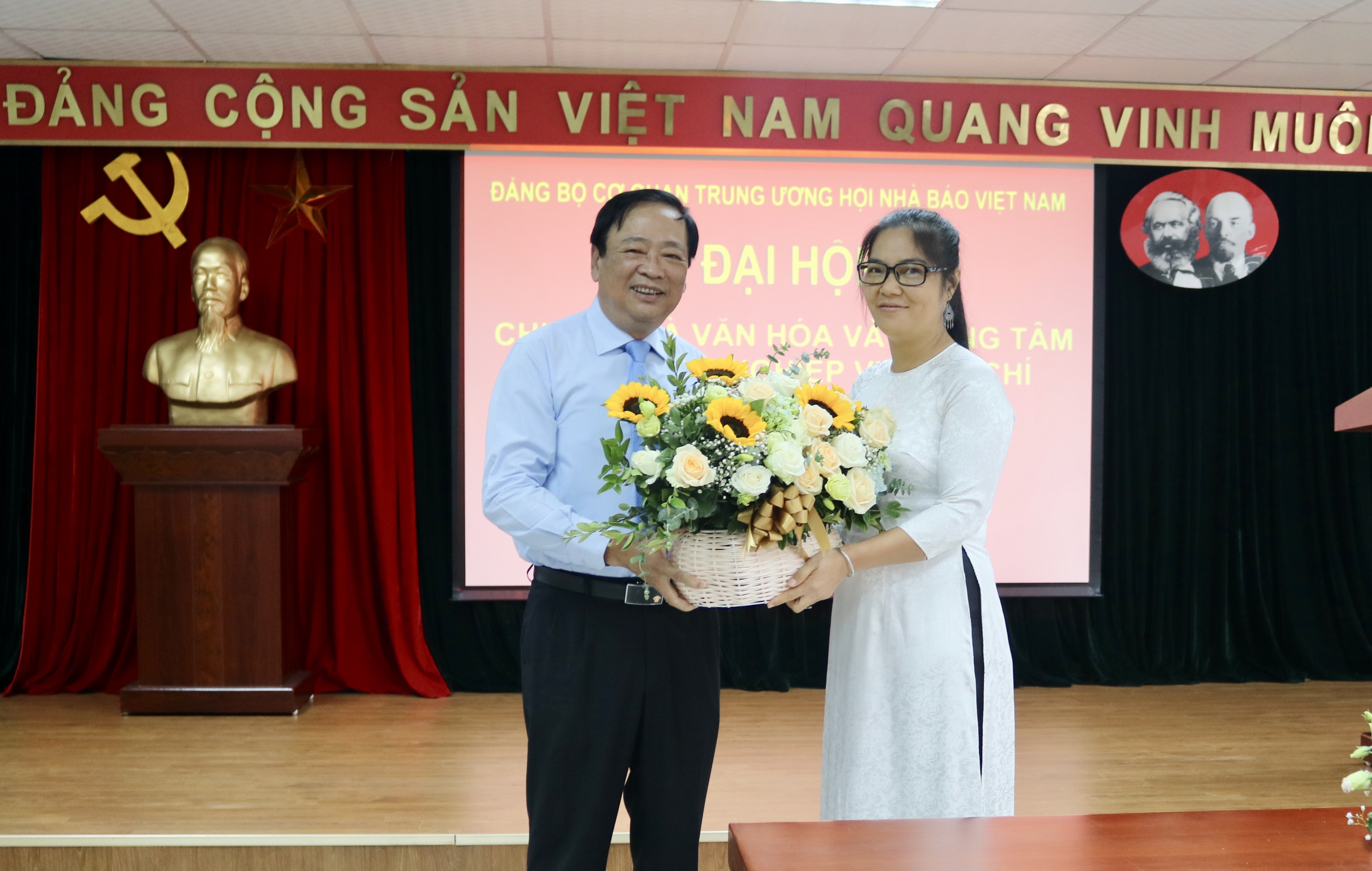 Đồng chí Mai Đức Lộc, Phó Chủ tịch Hội Nhà báo Việt Nam tặng hoa chúc mừng đồng chí Nguyễn Thị Hải Vân, Phó Giám đốc Trung tâm Bồi dưỡng nghiệp vụ báo chí làm Bí thư Chi bộ nhiệm kỳ mới.
