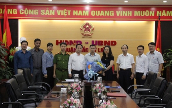 Lãnh đạo Quận Bắc Từ Liêm trao quyết định và tặng hoa chúc mừng ông Đỗ Chí Linh - Ảnh: Cổng TTĐT quận Bắc Từ Liêm