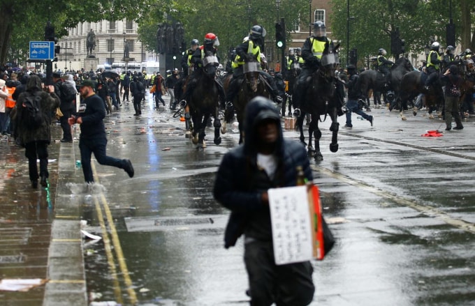 Cảnh sát đụng độ với người biểu tình tại London, Anh. Ảnh: Reuters