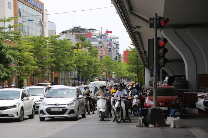 Người tham gia giao thông khi đến ngã tư chờ đèn đỏ đều tìm đến những vị trí có bóng mát như cây xanh hay cầu vượt, công trình đường sắt trên cao. Ảnh: Ngọc Ánh