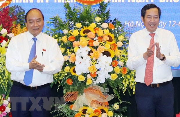 Thủ tướng Nguyễn Xuân Phúc tặng hoa chúc mừng ông Thuận Hữu, Ủy viên Trung ương Đảng, Tổng Biên tập Báo Nhân Dân, Phó Trưởng Ban Tuyên giáo Trung ương, Chủ tịch Hội Nhà báo Việt Nam. (Ảnh: Thống Nhất/TTXVN)