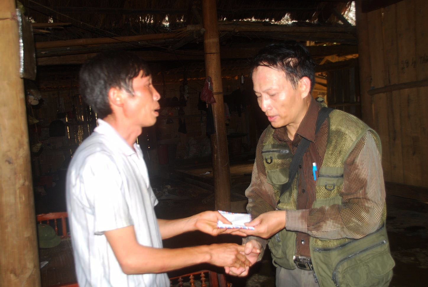 Nhà báo Đinh Quốc Hồng, phóng viên thường trú của Báo Nhân Dân tại Lào Cai chia sẻ mất mát với người dân bị lũ quét ở Nậm Chàm, xã Bản Cái, huyện Bắc Hà, tỉnh Lào Cai. Ảnh NVCC