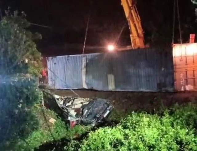 Lực lượng chức năng sử dụng cẩu kéo xe container để đưa các nạn nhân ra ngoài.