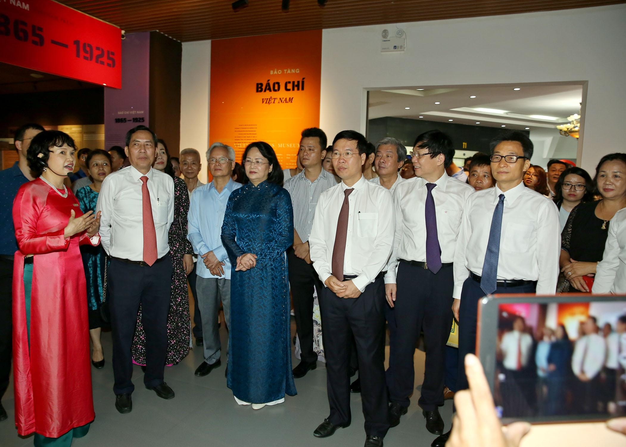 Các đồng chí lãnh đạo Đảng và Nhà nước, lãnh đạo Hội Nhà báo Việt Nam nghe giới thiệu về các giai đoạn của lịch sử báo chí Việt Nam. Ảnh: Sơn Hải
