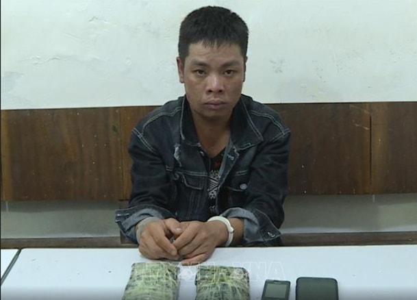 Đối tượng Bùi Văn Ngọc cùng tang vật là 2 bánh heroin. Ảnh TTXVN