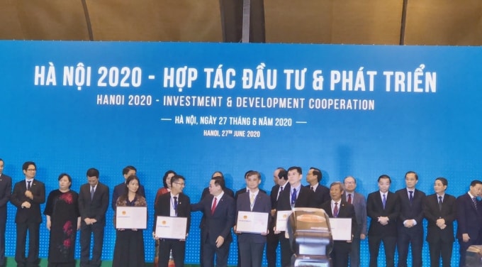 PCT Tổng công ty CP Thương mại Xây dựng nhận quyết định chủ trương đầu tư từ Bí thư Thành ủy Hà Nội Vương Đình Huệ. Ảnh: Hoàng Lâm.