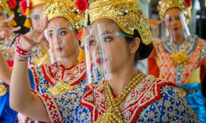 Các vũ công truyền thống Thái Lan đeo tấm chắn ngăn giọt bắn khi biểu diễn tại đền thờ Erawan ở Bangkok. (Nguồn: AFP)