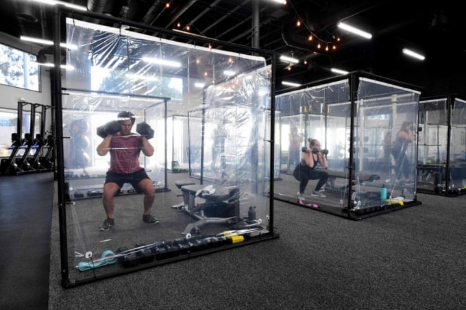 Các phòng tập gym ở Redondo Beach, California (Mỹ) đều lắp tấm chắn nilon để các hội viên hạn chế tiếp xúc. (Nguồn: AFP)