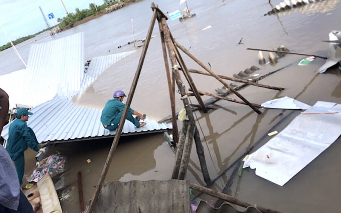 Lực lượng chức năng hỗ trợ người dân thu dọn nhà cửa đổ nát sau vụ sạt lở. Ảnh: TL.