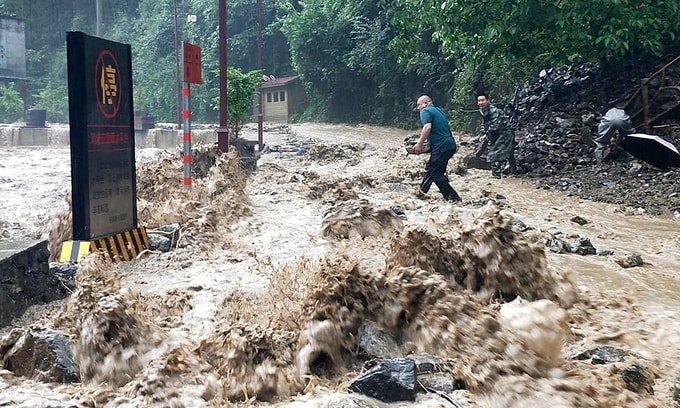 Lực lượng cứu hộ ngăn một đoạn đê vỡ do mưa lũ ở huyện Vu Khê, Trùng Khánh, hôm 12/6. Ảnh: Xinhua