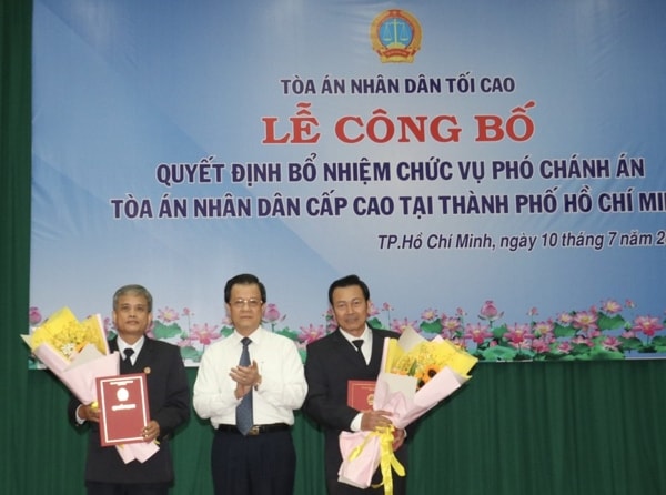 Ông Lê Hồng Quang trao quyết định và tặng hoa cho Chánh án và Phó chánh án TAND Cấp cao tại TP.HCM. Ảnh: PLO