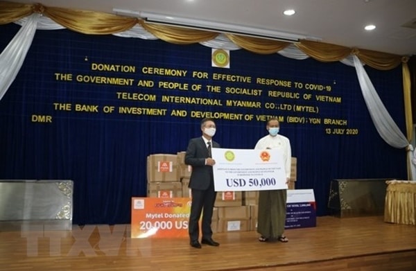 Đại sứ Lý Quốc Tuấn trao số tiền ủng hộ 50.000 USD cho phía Myanmar. Ảnh: TTXVN