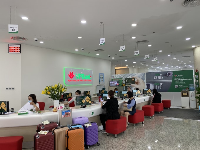 Người dân làm thủ tục triển khai thu NSNN qua các ứng dụng công nghệ tại quầy giao dịch của ngân hàng. Ảnh: Dương Lâm
