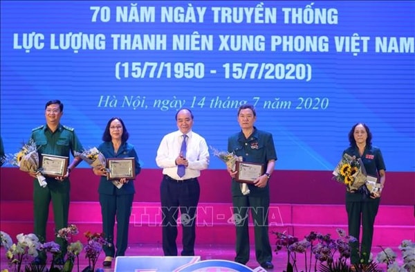 Thủ tướng Nguyễn Xuân Phúc tặng biểu trưng và hoa cho các cựu thanh niên xung phong tiêu biểu. Ảnh: TTXVN
