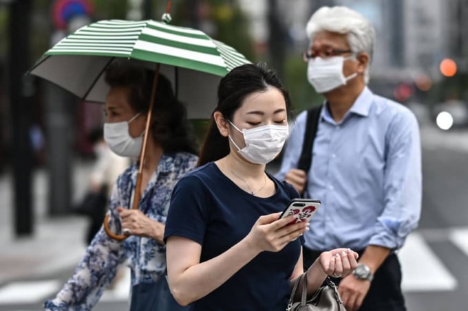 Mọi người đi bộ trên một đường phố ở Tokyo vào thứ Hai. Theo các nhà môi trường, bờ biển và vùng biển Nhật Bản đã chứng kiến sự gia tăng rõ rệt số lượng khẩu trang dùng một lần gần đây. Ảnh: AFP-JIJI