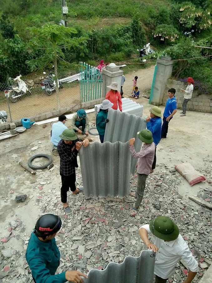 Trên nền đổ nát, người dân đang dùng tấm lợp để lợp lại mái nhà, ổn định cuộc sống